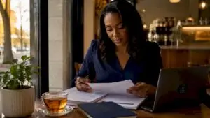 Woman sorting UK tax documents at kitchen table