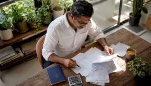 Director reviewing salary and tax papers at home