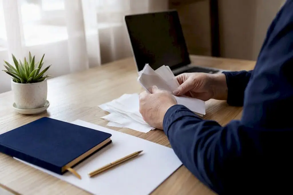 Hands sorting landlord bookkeeping receipts on desk