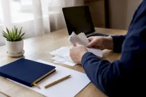 Hands sorting landlord bookkeeping receipts on desk
