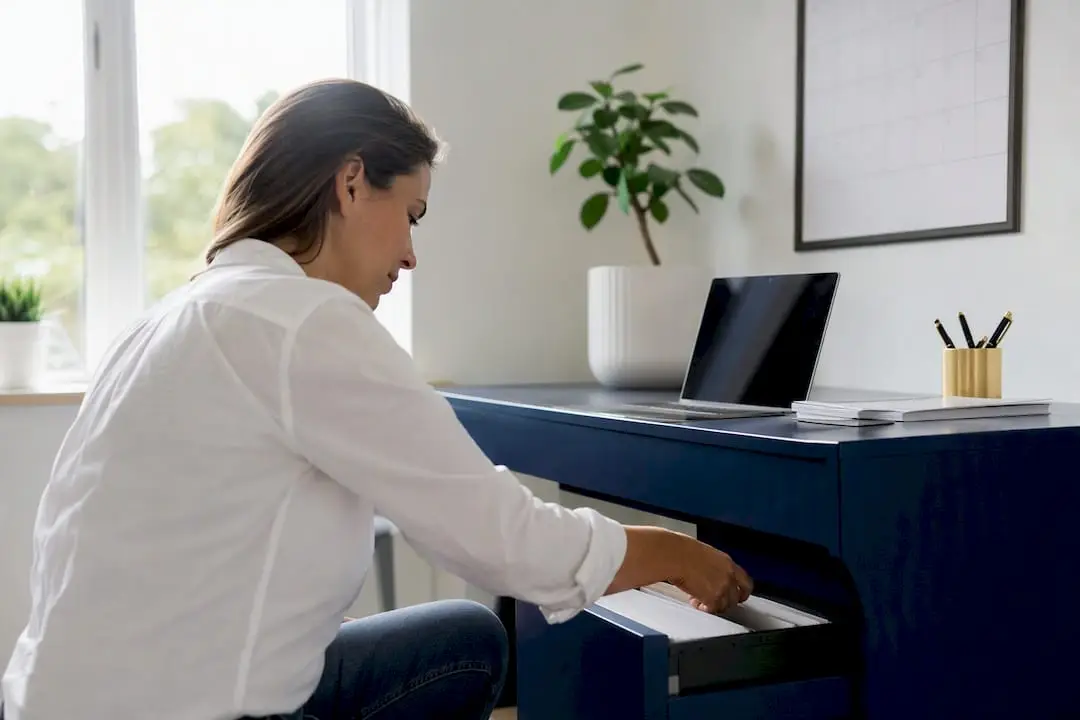 Hands unplugging desk phone in small office